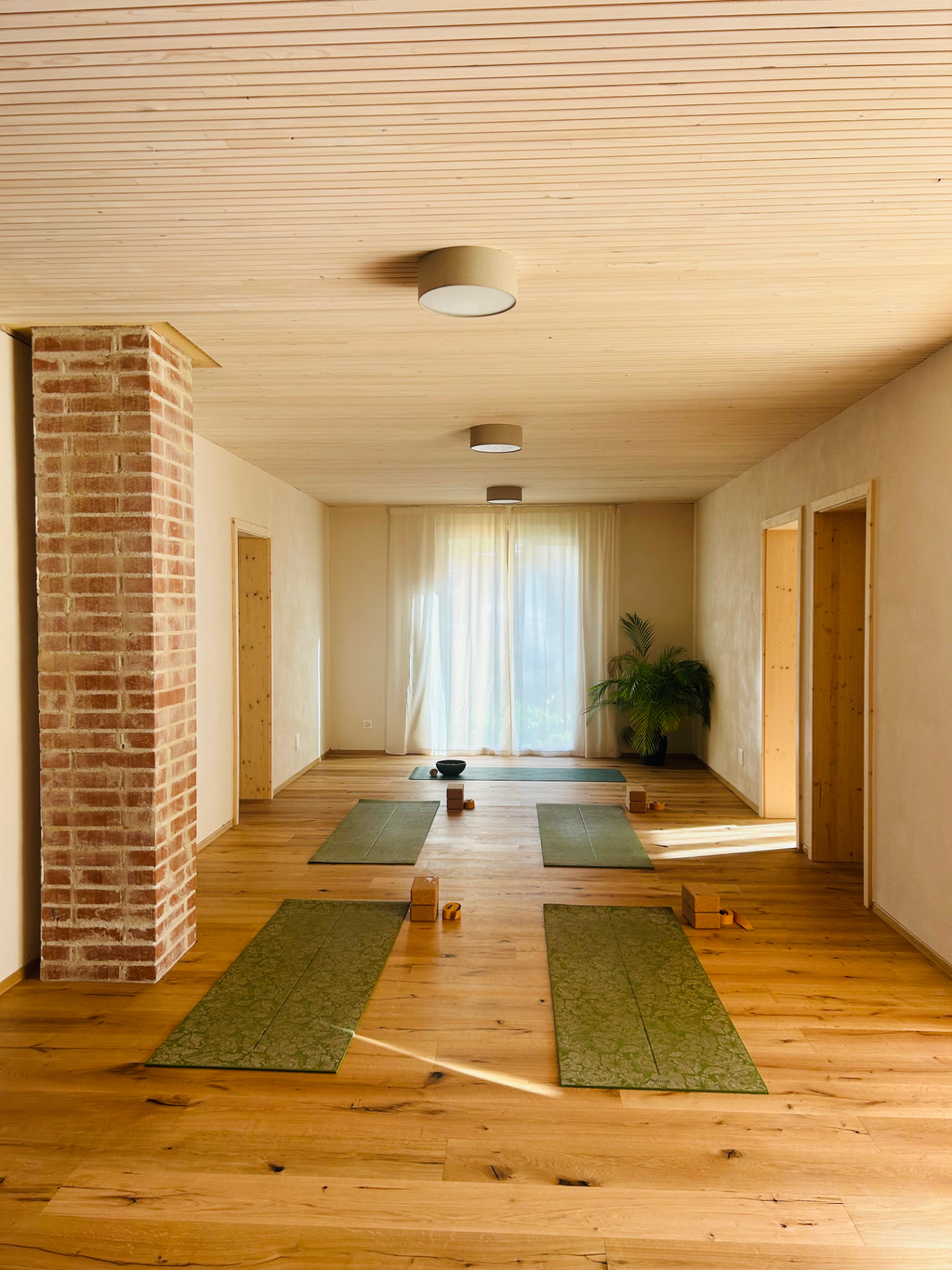Das Studio von Yoga with Gana in Vilters: ein heller Raum mit Holzboden, Yogamatten, Blöcken und viel Tageslicht.